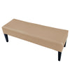 A tan stretch PU leather waterproof bench slipcover with black legs.