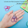 A hand holds a pair of purple precision craft scissors with a safety protective cover.