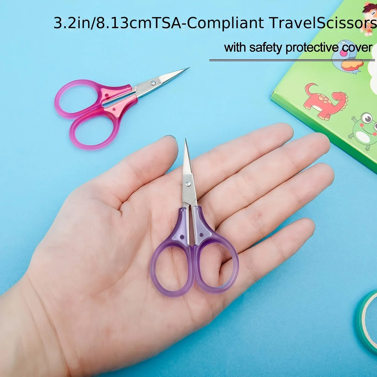 A hand holds a pair of purple precision craft scissors with a safety protective cover.