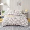 A light gray duvet cover with a white heart print is displayed on a bed in a bright room.