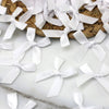 White satin ribbon bows arranged on a woven mat for crafts and decor