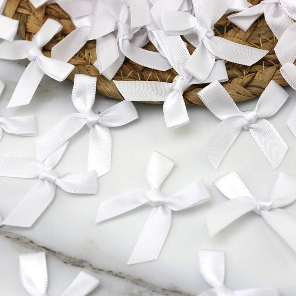 White satin ribbon bows arranged on a woven mat for crafts and decor