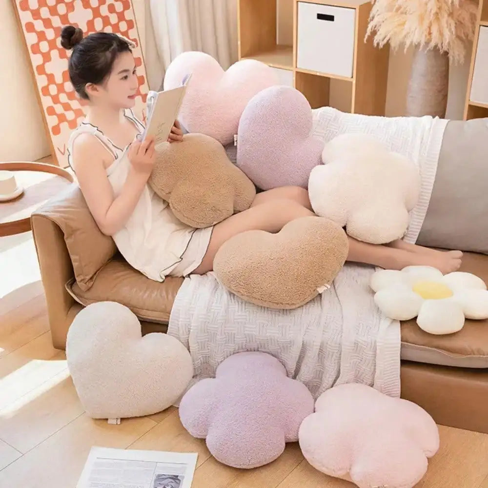 A collection of pink and beige heart-shaped plush cushions arranged on a sofa and floor.