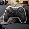 A black and white gamer controller plush resting on a gray blanket on a blue sofa.