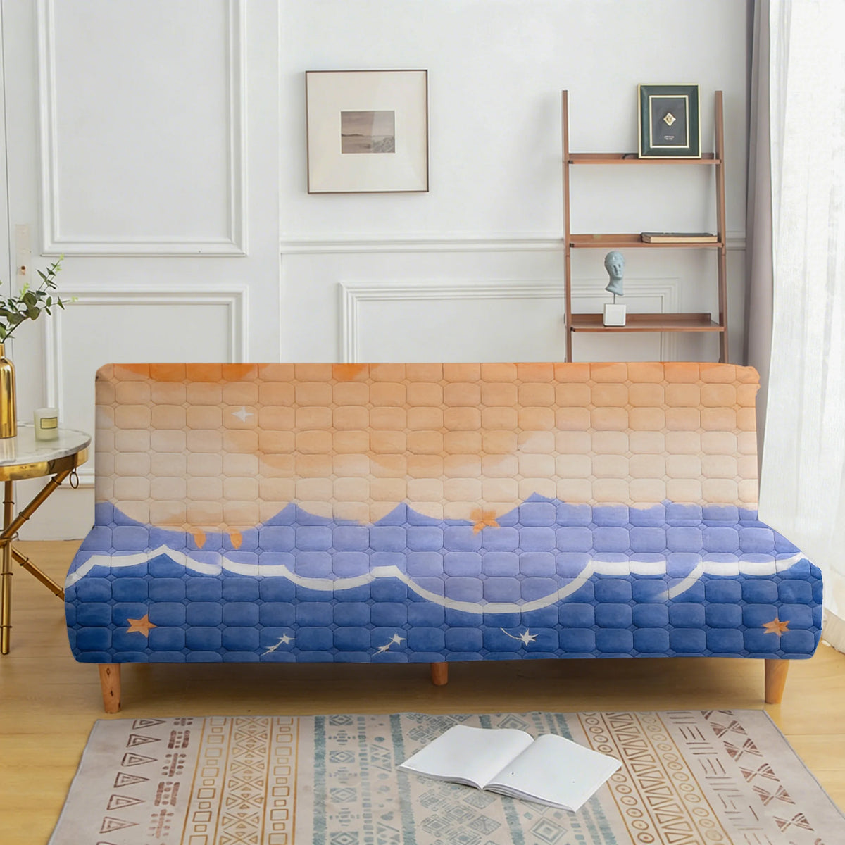 A blue velvet sofa cover with a quilted pattern is displayed on a wooden bench in a bright room.