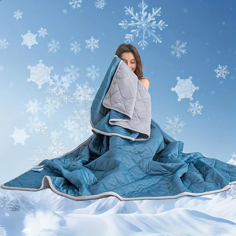 A woman is wrapped in a blue quilted blanket against a snowy, icy background.