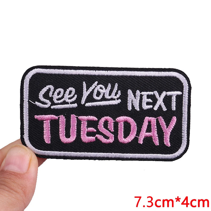 Black embroidered patch with pink text that reads See You Next Tuesday