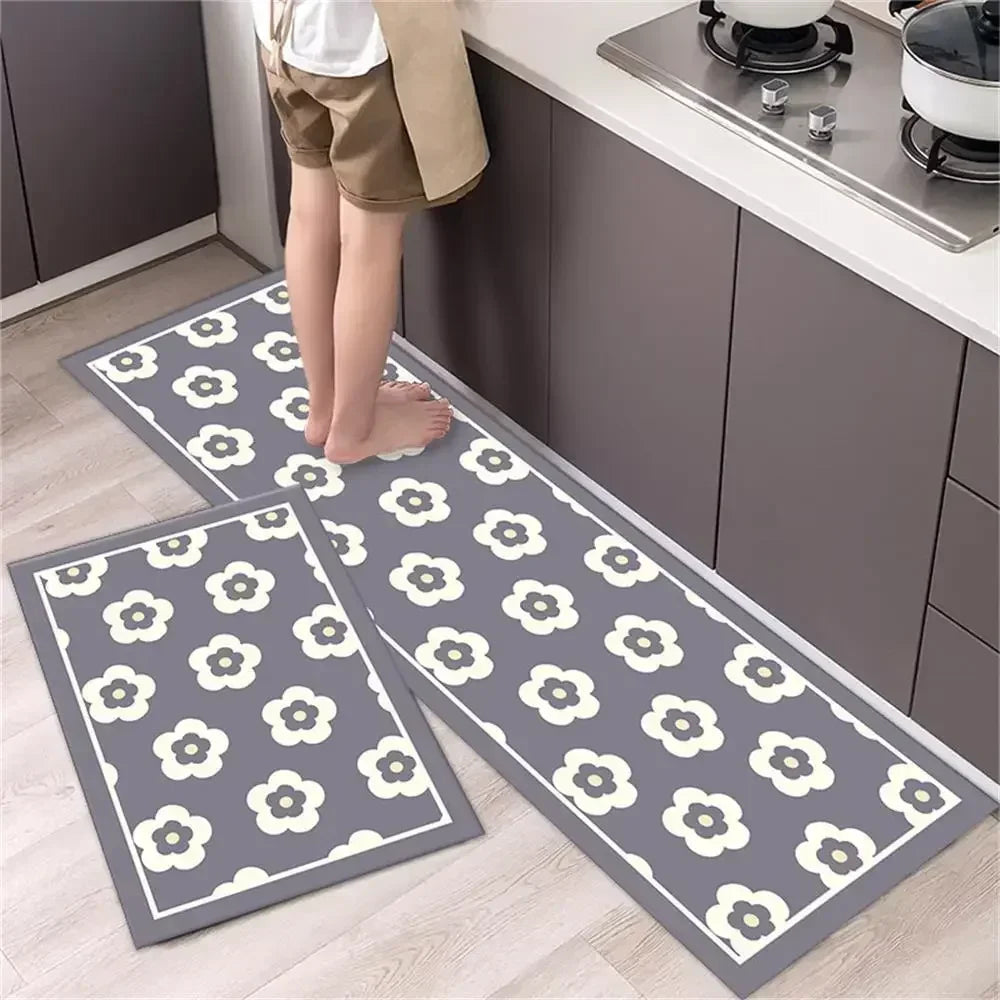 Two gray and white diamond print non-slip kitchen rugs laid out on a light wood floor.