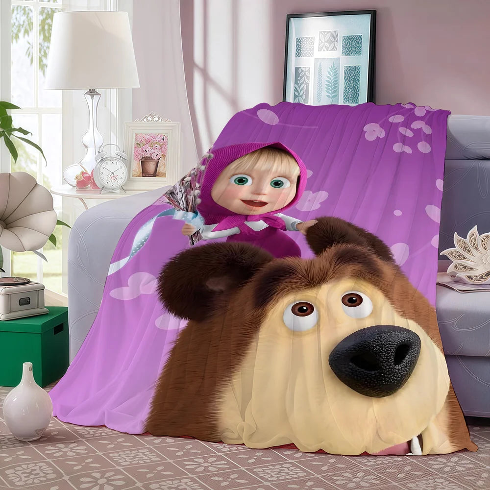 A plush fleece blanket featuring a cartoon bear character with large eyes and brown fur, draped in purple fabric.
