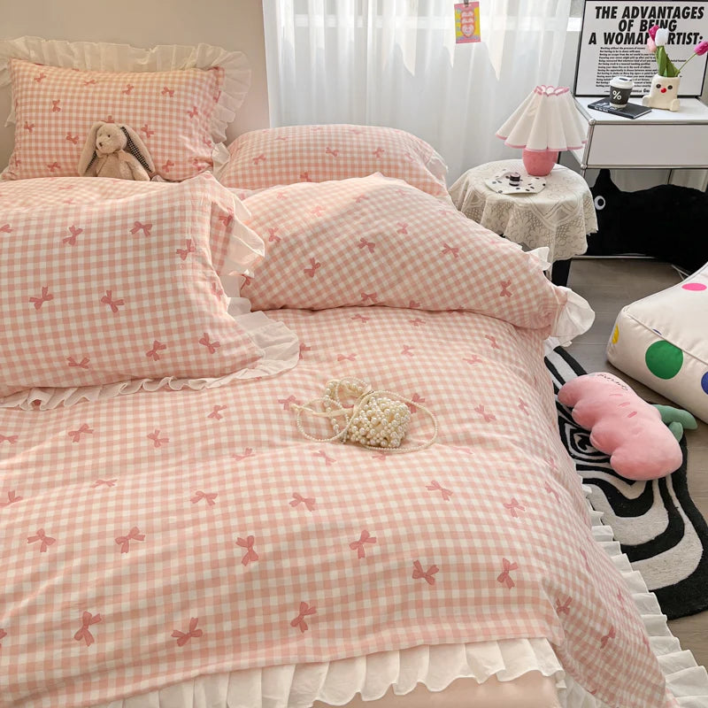 A pink and white gingham duvet cover set with floral bowknot accents displayed on a bed.