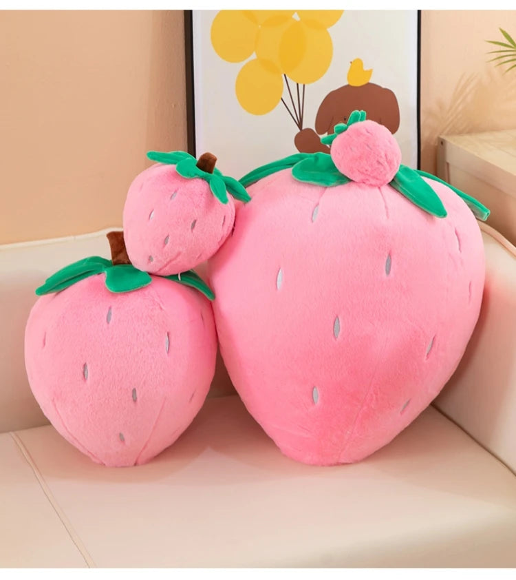 Pink plush strawberry throw pillow with green leaves and a brown stem