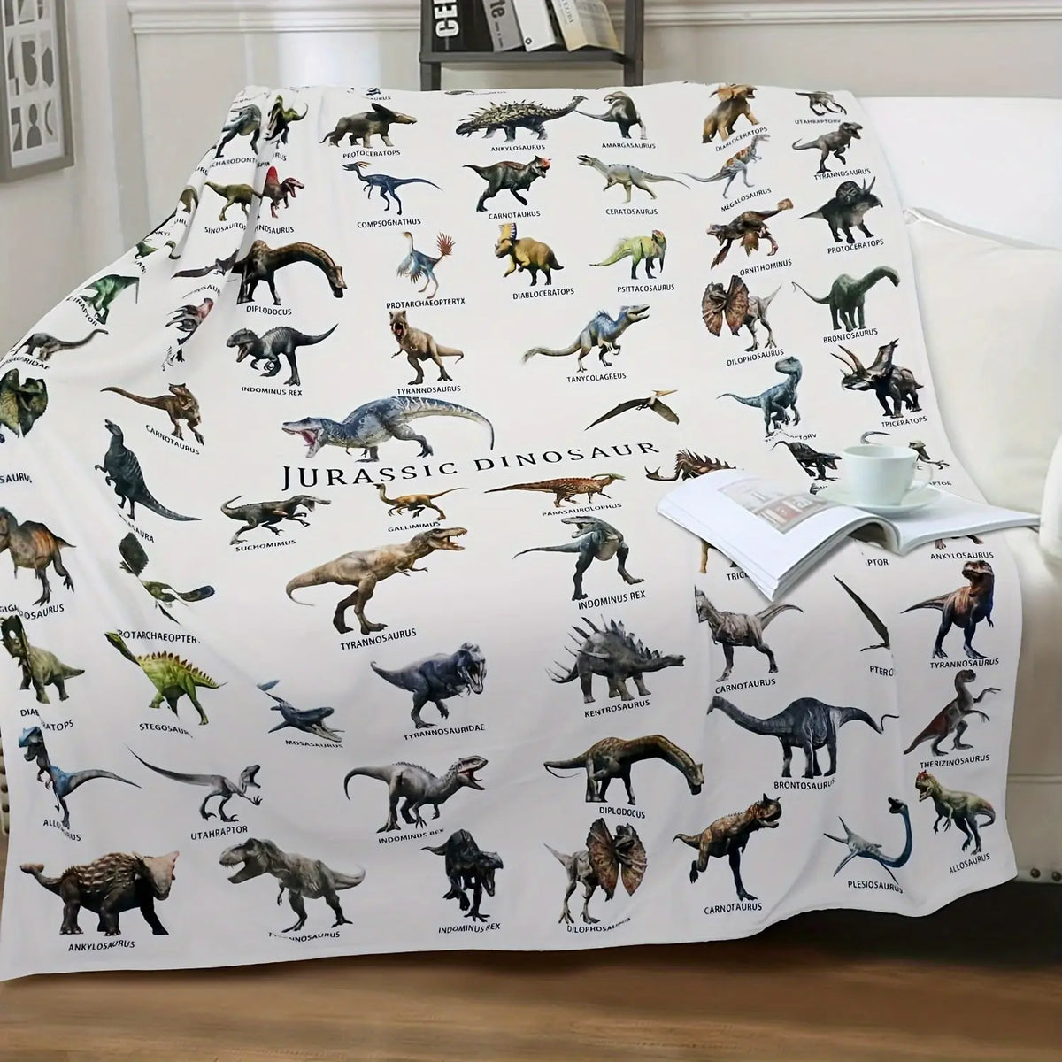 A white flannel throw blanket featuring various dinosaur illustrations and silhouettes.