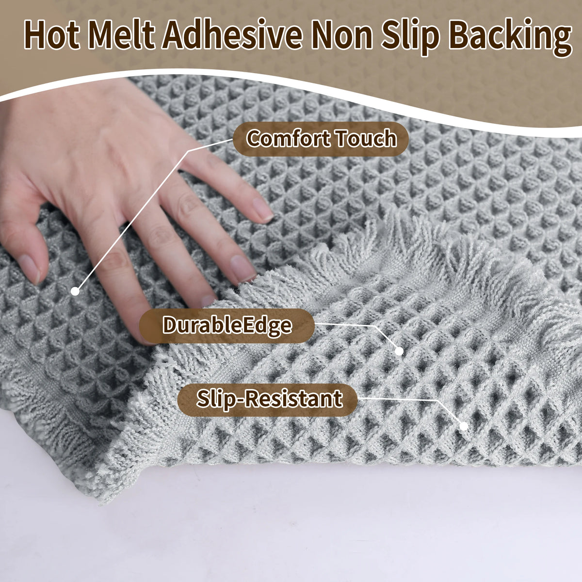 A hand touches a gray waffle design non-slip bathroom mat featuring comfort touch, durable edge, and slip-resistant propertie