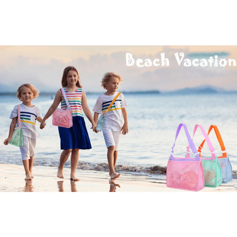 Three children walking on the beach with colorful mesh bags.