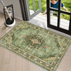 A vintage floral area rug with green and beige tones is displayed on a light wood floor near a glass door.