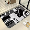 A black and white geometric patchwork floor mat is displayed on a light surface.