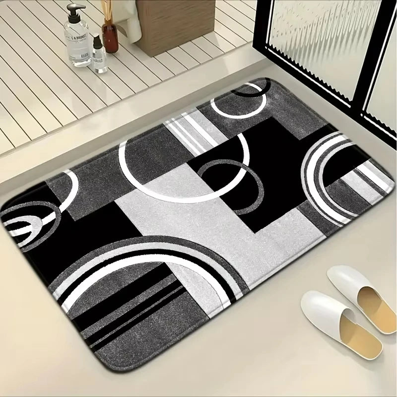 A black and white geometric patchwork floor mat is displayed on a light surface.