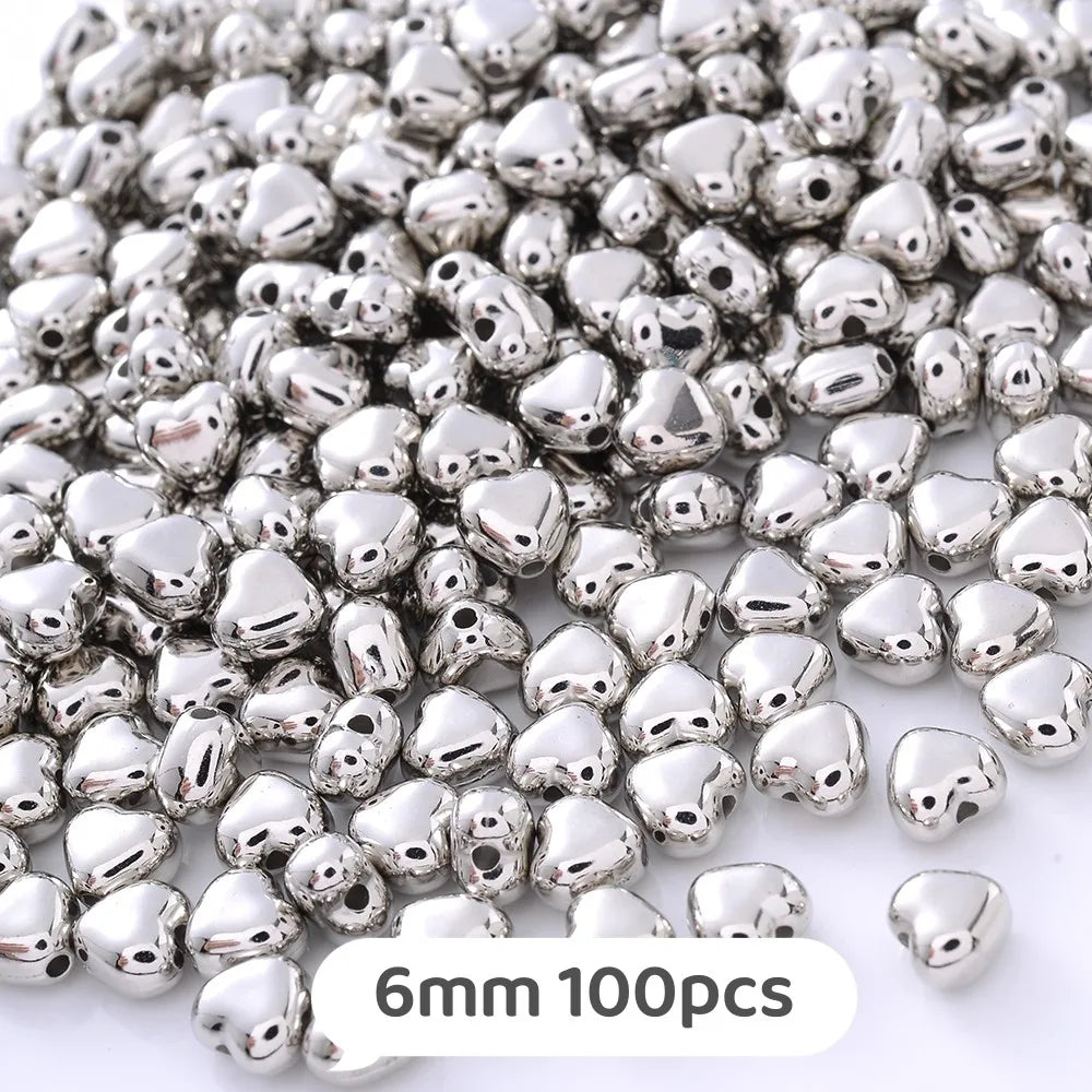 A pile of silver-toned geometric acrylic beads for jewelry making