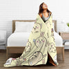 A beige flannel throw blanket featuring a repeating pattern of cute Chiikawa cartoon rabbits draped over a bed.