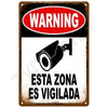 A vintage metal warning sign with a red oval saying WARNING and a black silhouette of a security camera, below which is text 