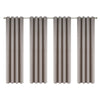 Set of four beige linen textured blackout curtains hanging on a rod.