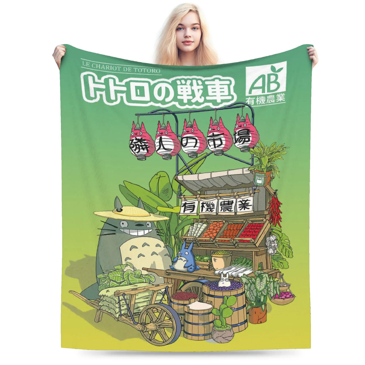 A green fleece throw blanket featuring an illustration of Totoro's driving car and related characters.
