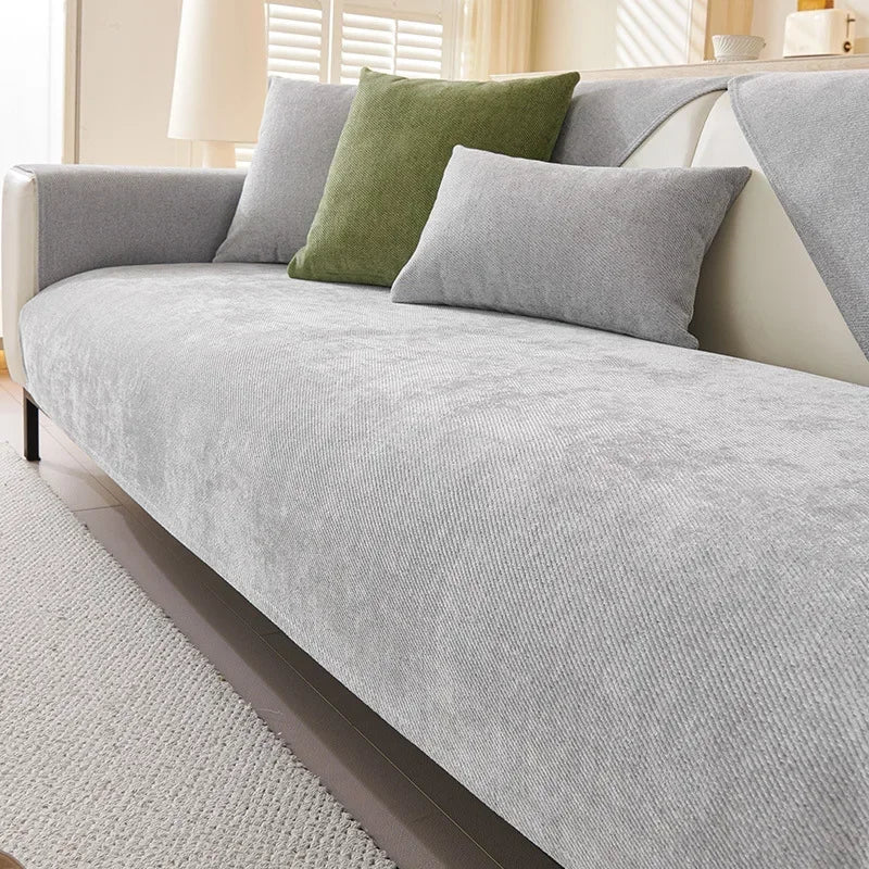A light gray chenille sofa cushion cover with olive green accent pillows on a modern sofa.