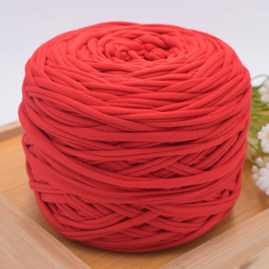 A ball of bright red craft yarn made of 100% polyester for knitting and DIY projects.