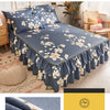 A dark blue printed bed skirt with white floral patterns is shown on a bed, highlighting its ruffled edge.