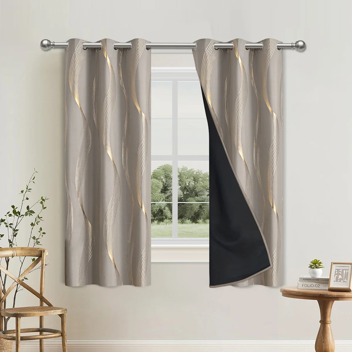 Gray blackout curtains with gold vertical stripes and a black panel hanging from a metal rod.
