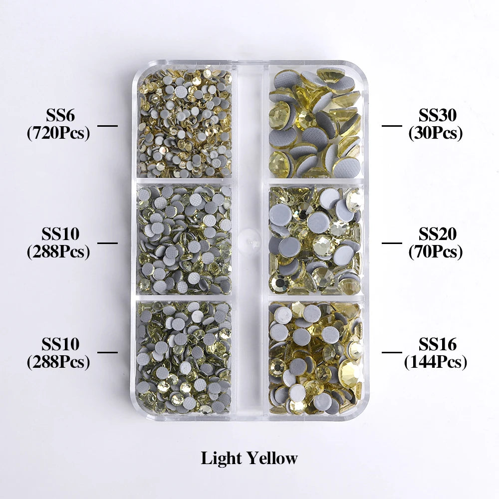 A clear plastic tray containing various sizes of light yellow glass rhinestones categorized by SS6, SS10, SS10, SS30, SS20, a