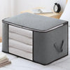 A gray portable storage bag with a zippered top and multiple internal compartments for clothing and quilts.