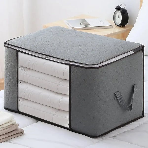 A gray portable storage bag with a zippered top and multiple internal compartments for clothing and quilts.