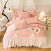 A pink princess chiffon duvet cover set with ruffled trim and decorative pillows displayed on a bed.