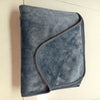 A soft, grey flannel blanket folded diagonally on a light surface.