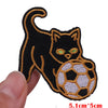 Black cat embroidered patch with glowing green eyes on a soccer ball background