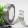 Roll of silver satin ribbon with gold edge for gift wrapping and crafts