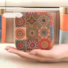 A hand holds a retro style zipper sewing kit storage box with colorful patchwork fabric.