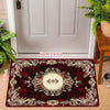 A deep burgundy luxury floral area rug with gold accents displayed in a doorway setting.