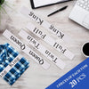 A collection of white labels with King, Queen, and Twin size text scattered on a wooden surface.