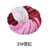 A ball of hand-woven chunky chenille yarn in shades of pink and maroon.