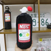 A black bottle shaped like a car neck pillow with a white and red animal figure, labeled Nos.