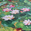 A close-up of a green and pink floral print fabric featuring lotus flowers on a textile.