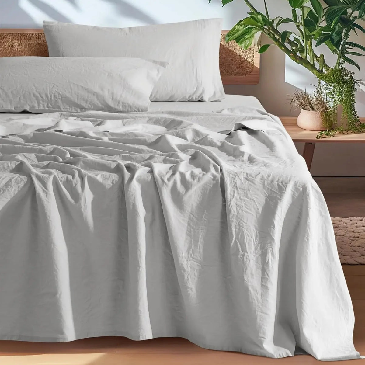 A white French stone washed linen bedding set featuring a duvet cover and pillows on a bed.