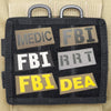 A black tactical hook and loop patch with five rectangular labels featuring acronyms like MEDIC, FBI, and DEA.