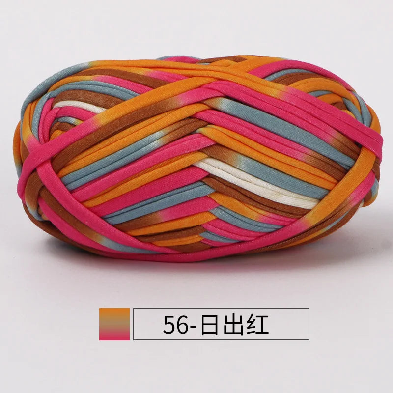 A ball of hand-dyed fabric strip yarn featuring stripes of orange, pink, and blue.
