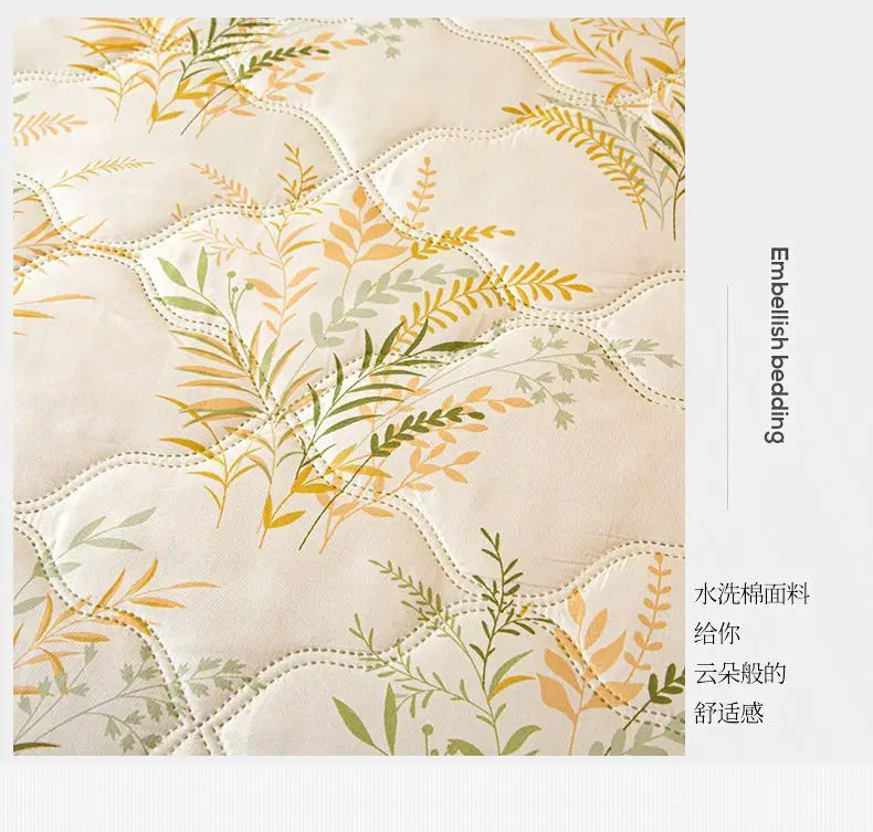 Light beige quilted fabric with delicate yellow and green botanical embroidery for bedding.