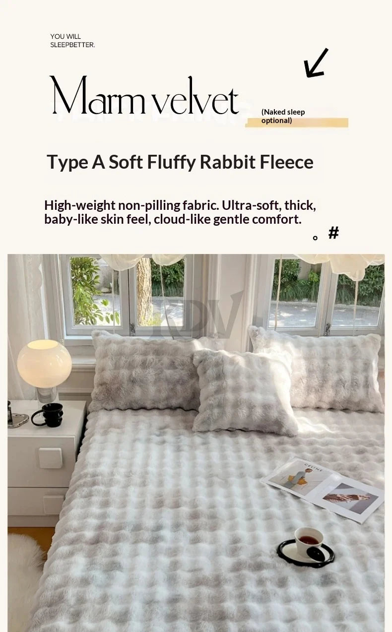 A light gray fleece blanket with white tufting is displayed on a bed, next to a window.