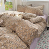 A beige floral microfiber duvet set with matching pillows displayed on a bed.