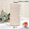 A roll of beige medium-thick hand-woven cotton yarn for crafting, with some light blue flowers in the background.